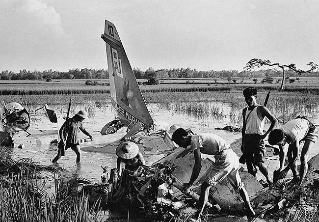  Miembtos de la Milicia inspeccionando un avión caído cerca de Hanoi. Fotógrafo de Vietnam del Norte